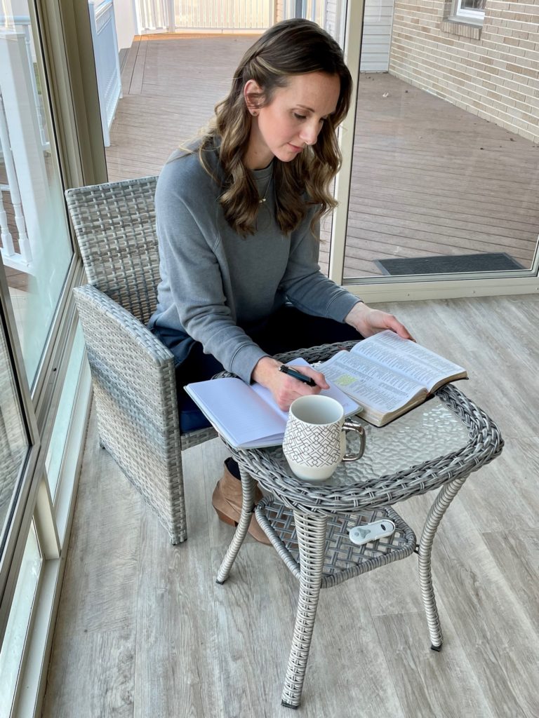 woman writing in journal and reading Bible